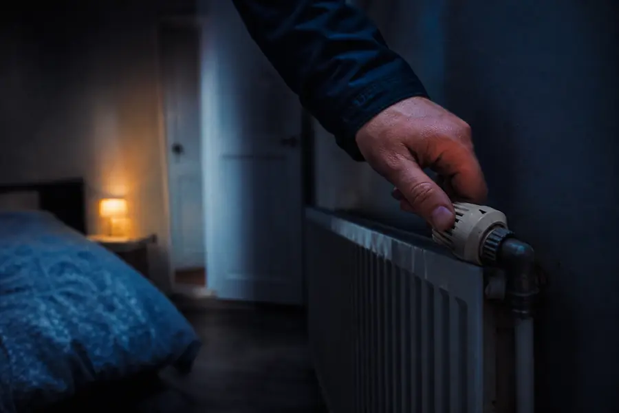 Robinet thermostatique de radiateur réglé sur une position basse dans une chambre peu utilisée d'un logement français.