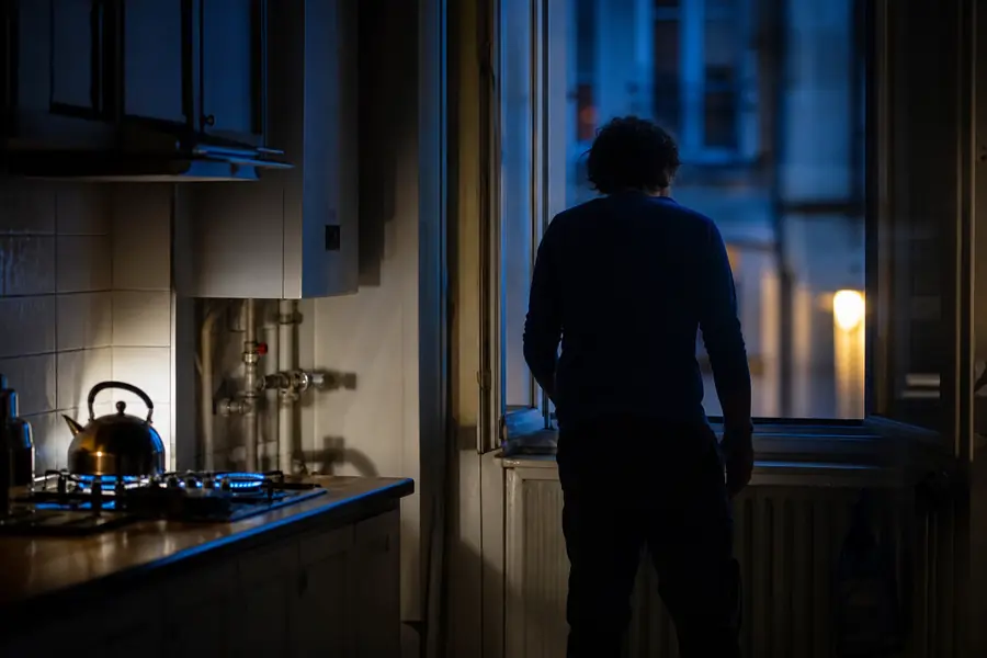 Fenêtre ouverte dans une cuisine sombre tandis qu’un occupant évacue face à un risque de fuite de gaz.