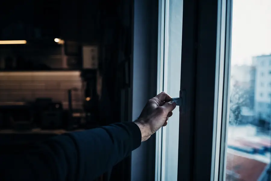 Main ouvrant une fenêtre pour ventiler un logement en cas de suspicion de fuite de gaz